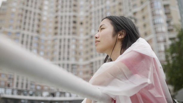 年轻的亚洲女子站在大都市，看着城市的风景，享受她的一天图片下载