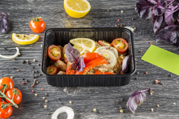 一个盘子放在一个黑色的一次性容器里，来自餐饮的混凝土背景，饮食餐饮，你的即食食品，健康食品图片下载