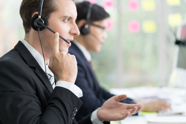 男性呼叫中心使用耳机支持在办公室工作的客户，与团队一起担任客服接线员。一组男性技术支持操作员在办公室客服图片下载