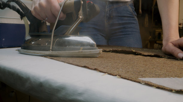 女裁缝在工作室熨烫布料图片下载