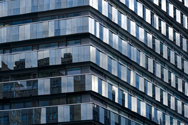 Close-up of modern glass facade of Triemli City Hospital with beautiful reflections on a cloudy winter day at City of Zürich.图片下载