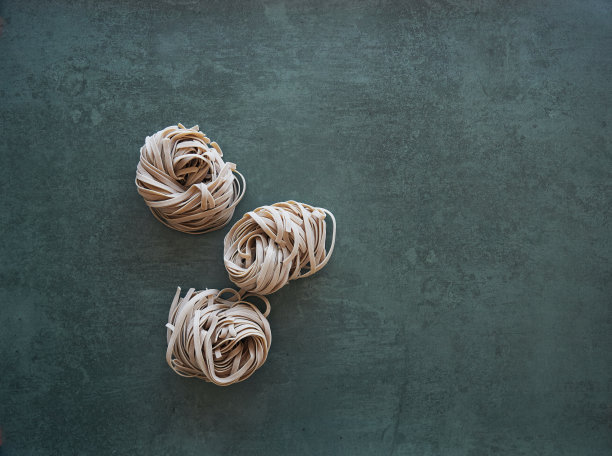 三个全麦意大利面孤立地窝在黑暗的背景上。俯视图，复制空间图片下载