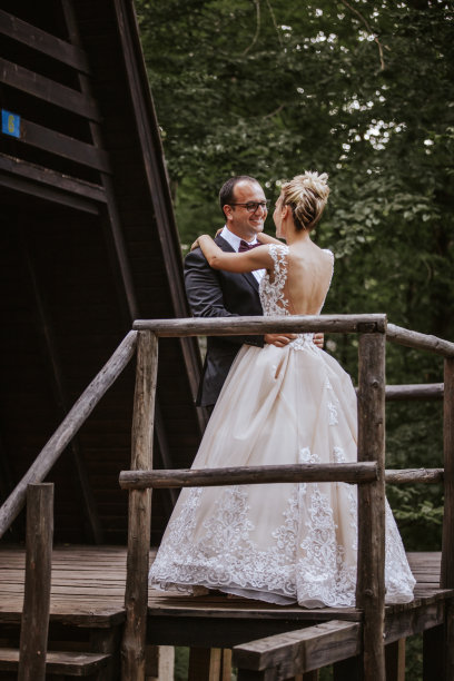 深情的年轻新娘和新郎在大自然的木制露台上跳舞图片下载