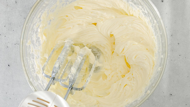 奶油奶酪和糖放在碗里。芝士蛋糕的食谱，在玻璃碗里混合原料，从上面特写图片下载