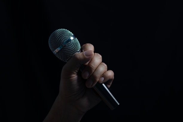 晚上舞台上男性手持麦克风，歌手概念、演讲、表演图片下载