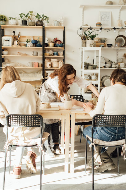 年轻女子在陶艺坊教徒弟制作陶瓷的肖像。图片下载