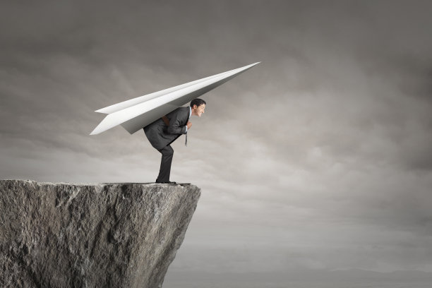 商人站在悬崖边，准备驾驶纸飞机起飞图片下载