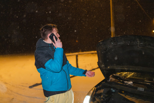 一个紧张的年轻人站在他被卡住的车前打电话图片下载