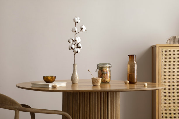 极简主义构图的餐厅室内圆形木桌，设计椅，花瓶干花，装饰，便盆和配件。时尚的家居装饰。模板。图片下载