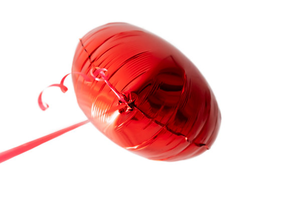 一个漂亮的大红色心形气球与丝带孤立在白色背景。漂亮的生日礼物。浮动对象。氦气充气球。情人节礼物。爱的象征图片下载