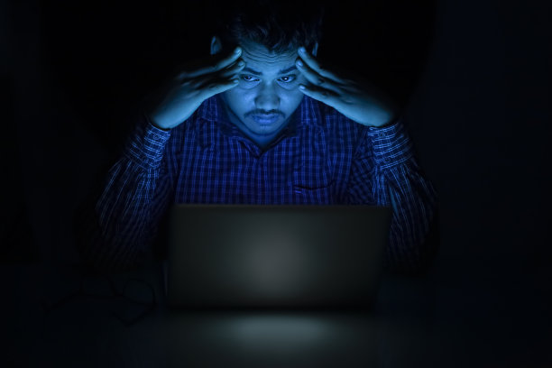 年轻人在午夜使用笔记本电脑感到困倦图片下载