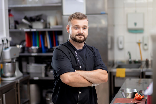 专业厨师穿着制服在厨房切新鲜蔬菜。厨师在餐厅为顾客烹制美味的配菜。烹饪概念图片下载