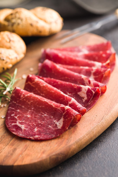 烟熏bresaola。意大利开胃菜。牛肉干放在砧板上。图片下载