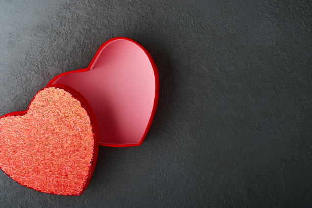 红色性感内衣和内裤在盒子上的黑色背景。女人性感内衣套装与玫瑰和香水。妇女节或情人节的礼物创意与复制空间。不论是对男人还是对他来说都是惊喜。俯视图图片下载