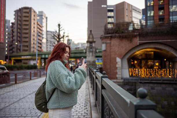 年轻的女游客在桥上拍照图片下载