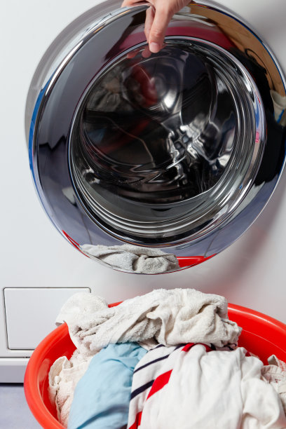 洗好的衣服放在洗衣机前的脸盆里图片下载