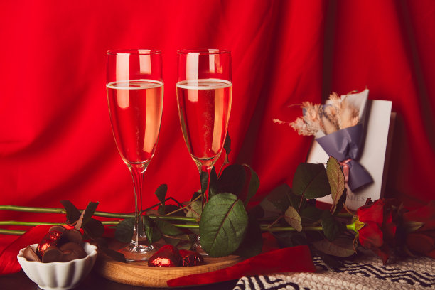 传统浪漫的情人节-红玫瑰，香槟，眼镜，糖果和明信片图片下载