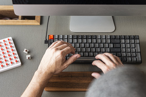 人们在台式电脑上工作，它的现代灰色键盘。这是非常舒适和有用的。图片下载
