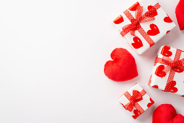 情人节的概念。俯视图照片的礼物盒与红丝带蝴蝶结和心形软玩具在孤立的白色背景与复印空间图片下载