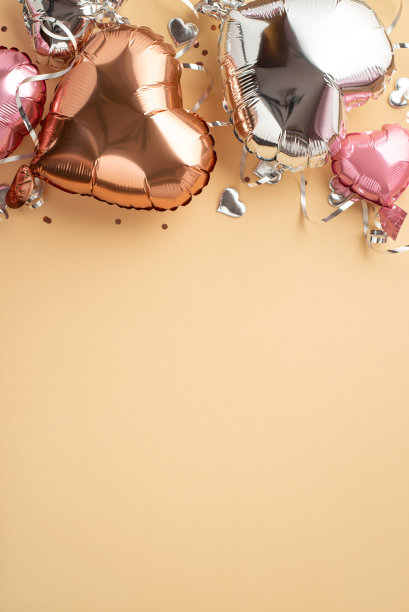 情人节氛围概念。顶部查看垂直照片的粉红色金色银色心形气球蛇形和五彩纸屑在孤立的粉彩米色背景与空白图片下载