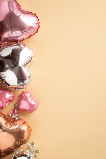 情人节装饰概念。顶部查看垂直照片的粉红色金色和银色心形气球在孤立的粉彩米色背景与空白图片下载