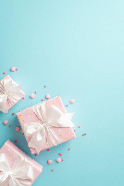 情人节的概念。俯视图垂直照片浅粉色的礼物盒与白色丝带蝴蝶结和心形洒在孤立的淡蓝色背景与空白图片下载