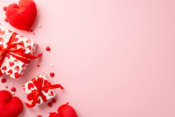 情人节的概念。顶视图照片的礼品盒带蝴蝶结心形软玩具和洒在孤立的粉彩粉红色背景与复制空间图片下载