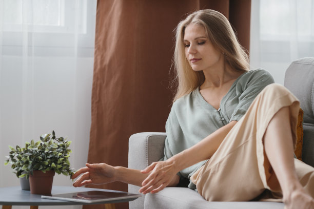 漂亮的金发年轻女子插画家在平板电脑上画画。图片下载