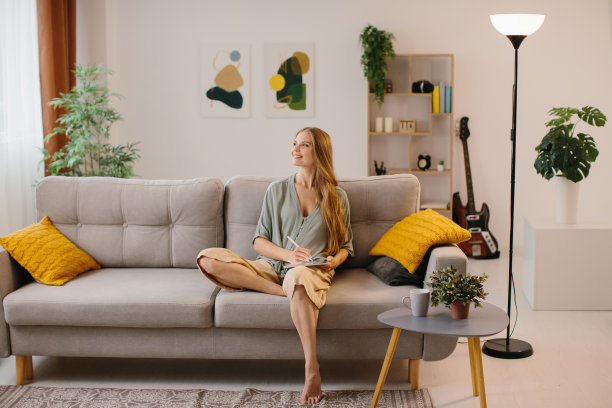 快乐的年轻设计师在绘图板上用触控笔画画。女平面设计师微笑，而工作在一个新的设计。有创造力的年轻自由职业者在她的家庭办公室工作。图片下载