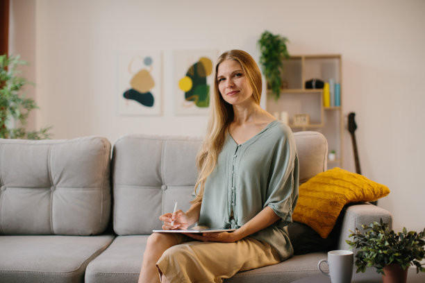 快乐的年轻设计师在绘图板上用触控笔画画。有创造力的年轻自由职业者在她的家庭办公室工作。图片下载