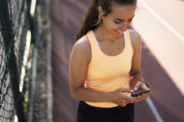 穿着运动服的漂亮女人在打电话图片下载