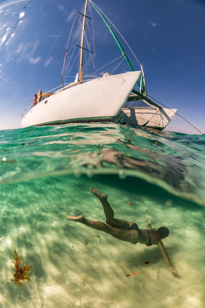 一名女子在帆船下自由潜水图片下载