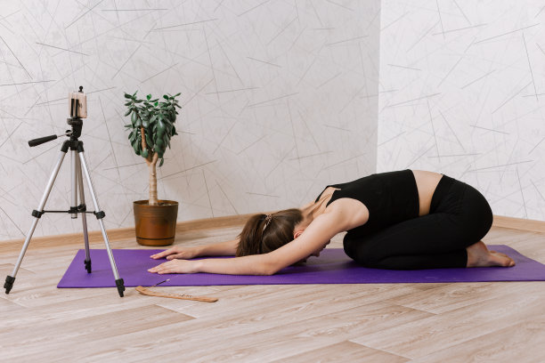 灵活的女运动员在地板垫子上做瑜伽练习图片下载