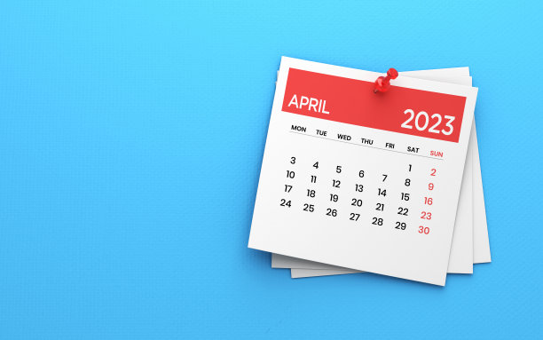 2023在蓝色纸背景照片上贴上四月日历和红色图钉图片下载