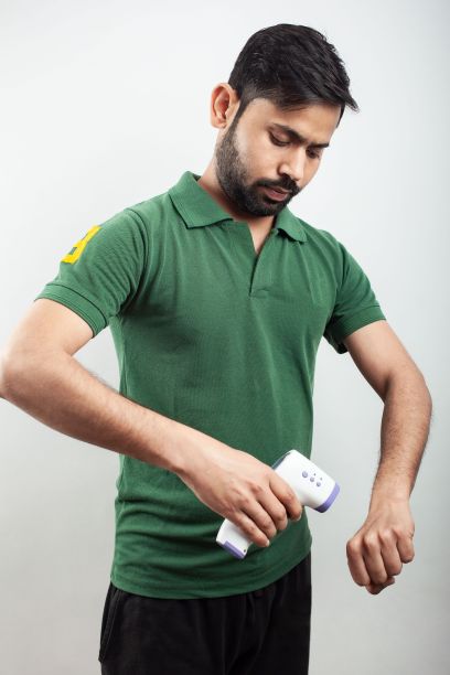 在白色背景下，男子用红外数字体温计测量体温图片下载