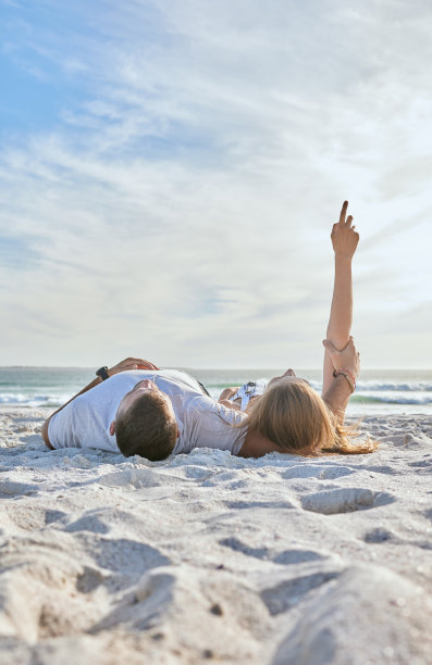 海滩，放松和情侣在海边度假，冒险或旅行时看天空。旅行，在澳大利亚度假时，男人和女人一起在海边的大自然中休息。图片下载