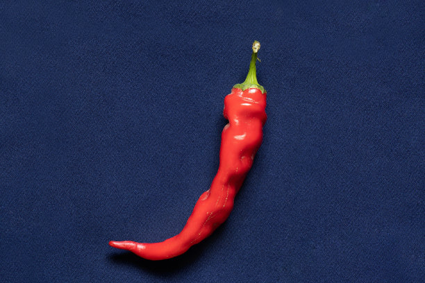 红辣椒在彩纸背景上图片下载
