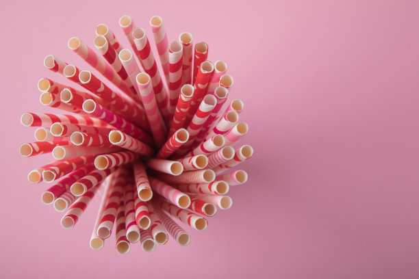 为情人节喝吸管。粉色背景上的红色、粉色和白色派对纸吸管图片下载