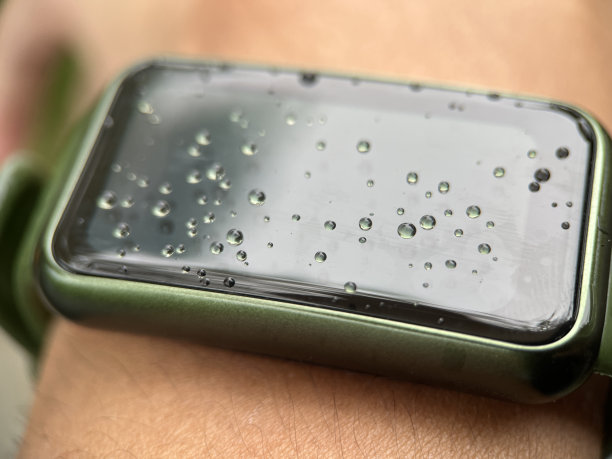 成年人佩戴的智能手表屏幕上的水滴图片下载