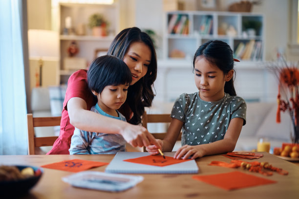 中国家庭享受着在红色的纸上书写新年庆祝活动。图片下载