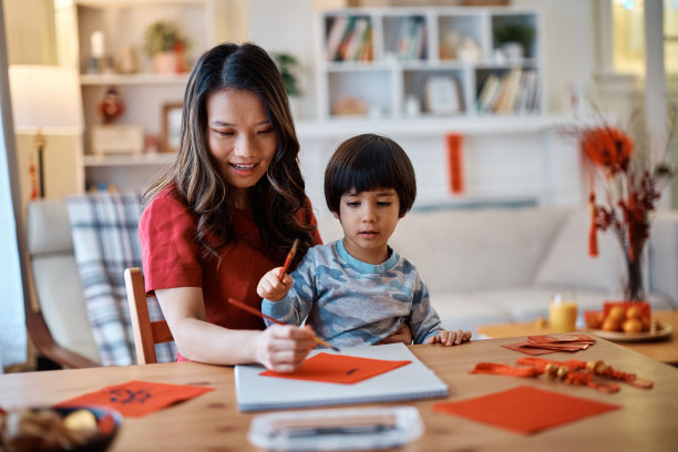 中国母亲和儿子在家里写书法庆祝新年。图片下载