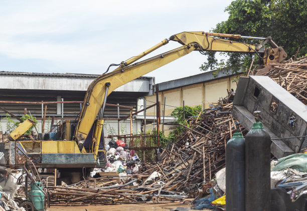 回收厂的黄色挖掘机图片下载