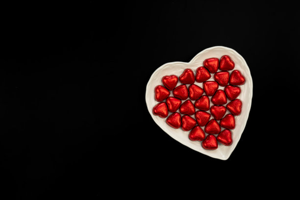 心形盘子，黑色背景，心形巧克力，平放。图片下载