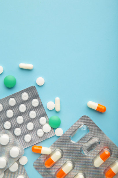 补品和药片用蓝色背景包装。药剂师和诊所。垂直的照片。图片下载