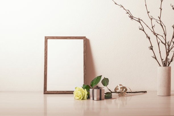 模板和相框放在木桌上。白玫瑰。花瓶里的干植物。图片下载