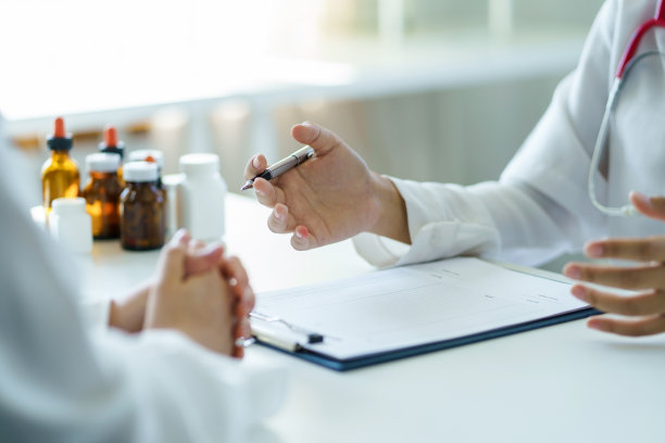 医生正在询问病人的症状和记录。图片下载