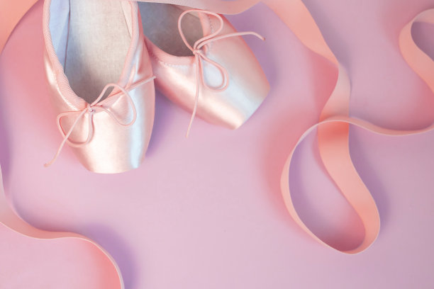 浪漫的背景。粉色芭蕾足尖鞋与丝带在粉红色的背景。发短信的地方。前视图。图片下载