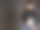 一名年轻的拉丁男子，穿着黑色毛衣和蓝色牛仔裤，背着一台笔记本电脑，背景是灰色的图片下载
