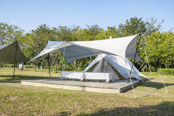 在晴朗的天空下，公园草地上的露营帐篷图片下载