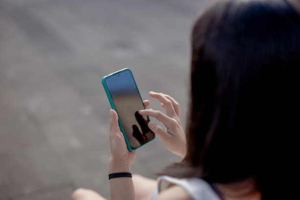 一个女人在城市里使用手机图片下载